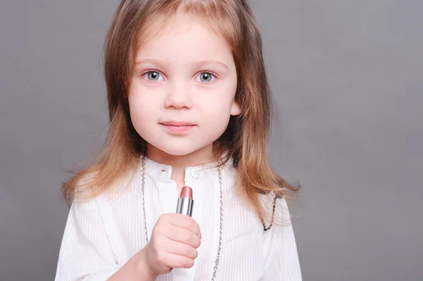 Piccola ragazza che tiene il rossetto — Foto Stock