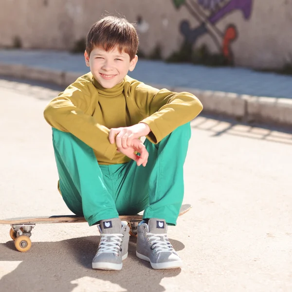 Jongen zit op skateboard — Stockfoto