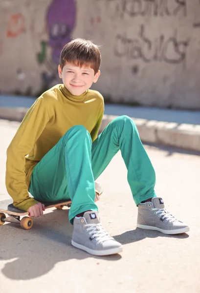 Boy sitting on skateboard — Stock Photo, Image