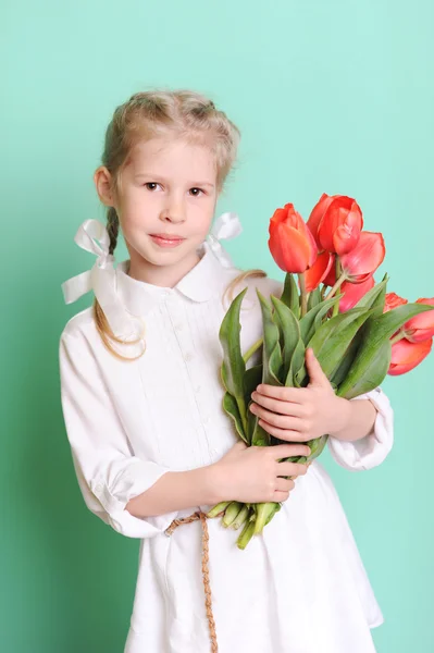 Маленькая девочка с тюльпанами — стоковое фото