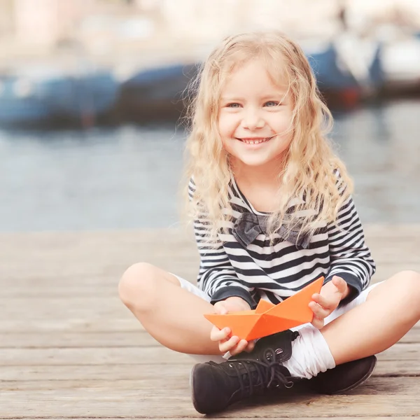 Girl playing with paper boat — Stock Photo, Image