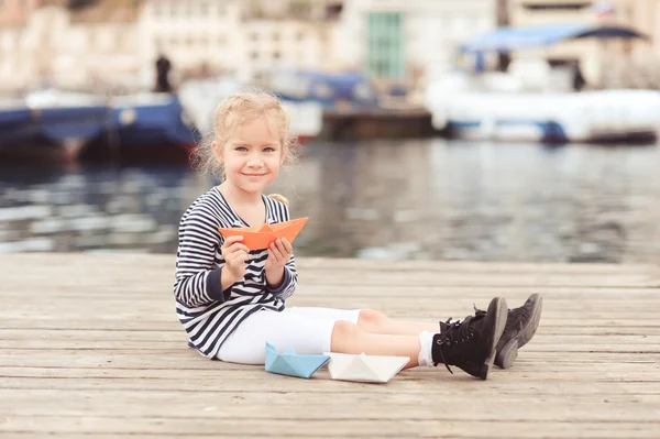 Menina segurando barco de papel — Fotografia de Stock