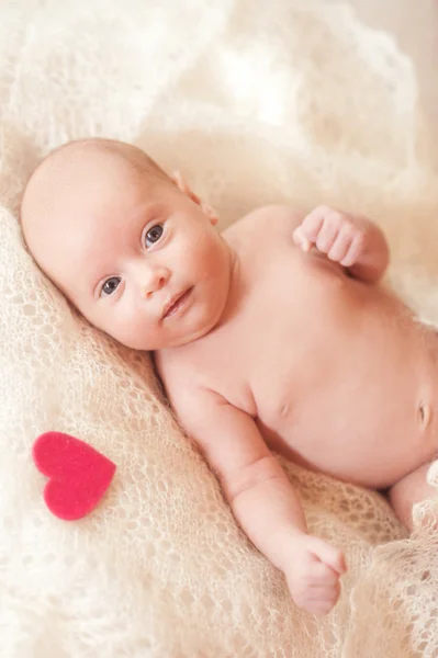 Niña acostada con corazón rosa — Foto de Stock