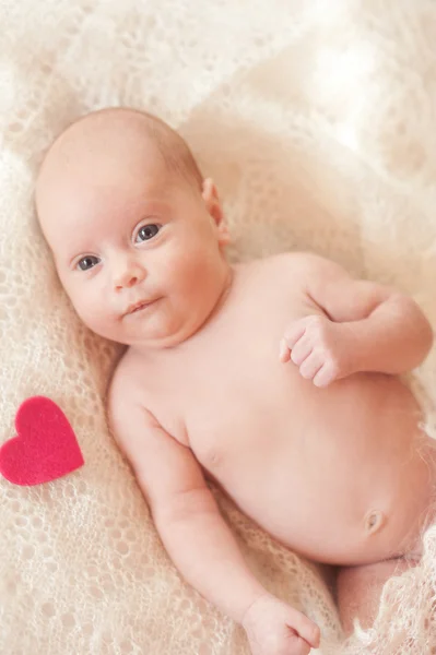 Bebê menina deitada com coração rosa — Fotografia de Stock