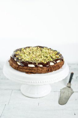 beyaz zemin üzerine Antep fıstığı ile çikolatalı kek