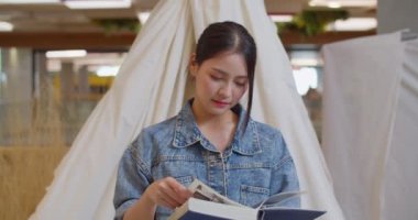 A beautiful Asian woman is happy to read a book. 4K DCI (The submitted footage is a grouping shooting arrangement)