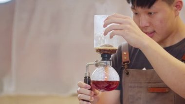Professional baristas making coffee like a Siphon Coffee Maker. 4k Slow Motion video  (The submitted footage is a grouping shooting arrangement)