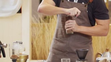 Professional baristas grind coffee with a manual grinder in a manual process.