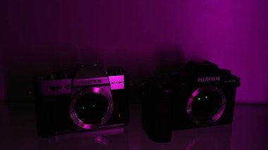 Fujifilm X-S10 vücut siyahı ve Fujifilm X-T30 vücut gümüşü, morötesi. Neon rengi, mor renk.