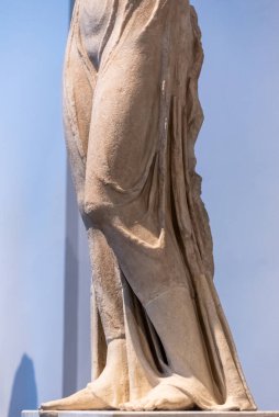 Eski taş heykellerden birinde, tunik giyen bir kadın.