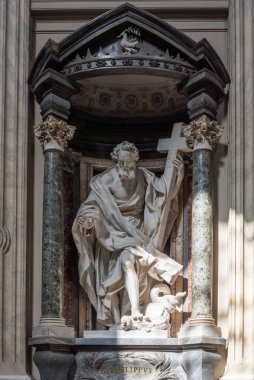 Katolik azizin mermer heykeli bir haç tutuyor ve Roma 'da kilisede bir canavarın üzerine basıyor.