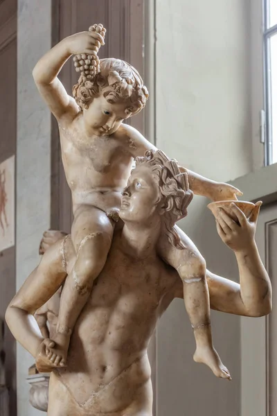 在古代大理石雕像上的特写 该雕像代表了一个赤身裸体的年轻人 肩上抱着一个拿着一串葡萄的男孩 — 图库照片