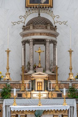 Detail of catholic altar with golden candlesticks and crucifix