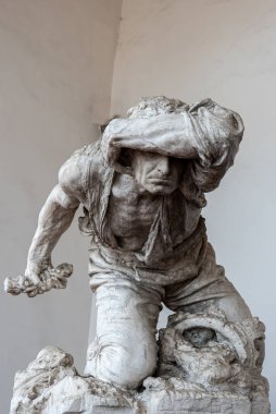 Close-up on marble statue of vagabond man hiding his head