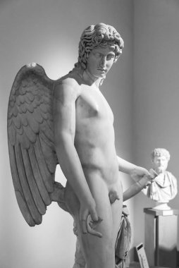 Black and white photo of marble statue representing an adult male angel naked
