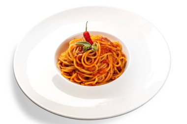 Domates soslu, sarımsaklı, maydanozlu ve biberli beyaz tabakta acı biberli spagetti.