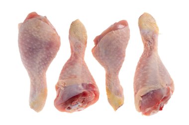 İzole edilmiş beyaz zeminde dört çiğ tavuk bacağı.