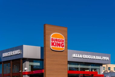 Moncalieri, Torino, İtalya - 6 Aralık 2021: Torino yakınlarındaki Moncalieri 'de Fortunato Postiglione üzerinden bulutlarla mavi gökyüzünde Burger King Restaurant' ın yeni logosunun imzası