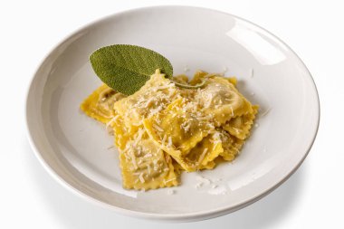 Tereyağlı ve adaçayı soslu Ravioli makarnası rendelenmiş parmesan ve adaçayı yaprağı beyaz tabakta izole edilmiş, kırpma yolu.