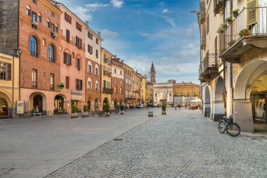 Savigliano, Cuneo, Piedmont, İtalya - 2 Eylül 2021: Piazza Santarosa ana meydanı ve tarihi atari salonlu binalar. Arka planda zafer kemeri