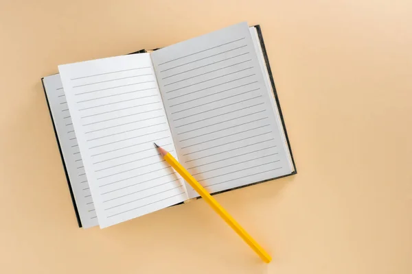 Notebook Forrado Aberto Com Lápis Amarelo Isolado Fundo Marrom Claro — Fotografia de Stock