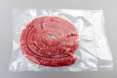 Süpürgeye doldurulmuş İtalyan sosisi (salsiccia) sous vide pişirme için kapalı üst görünümde gri arkaplanda izole