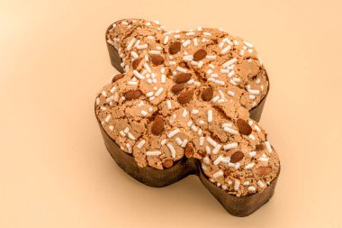 Açık kahverengi arka planda Colomba Pasquale, şeker kaplı ve bademli tipik İtalyan paskalya pastası. İngilizce Paskalya Güvercini.