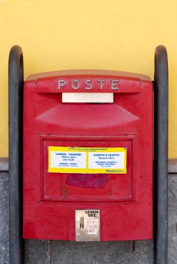 Fossano, Cuneo, İtalya - 07 Mart 2022: İtalyan Posta Ofisi 'nin kırmızı posta kutusu sarı bir duvarda posta koleksiyonu zamanlarıyla birlikte
