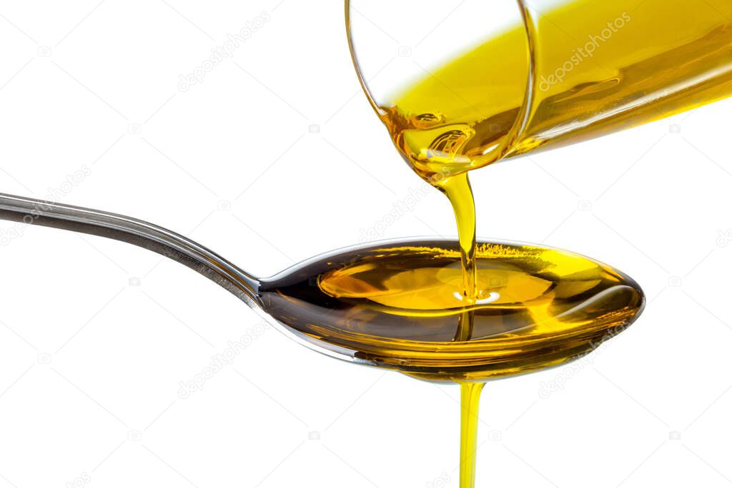 Extra virgin oil poured from bottle into spoon, isolated on white background, clipping path
