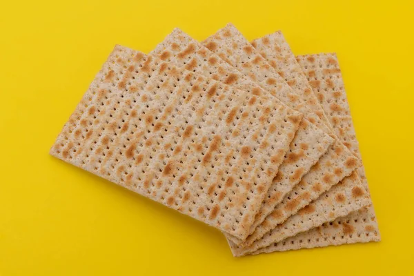 Hamursuz Bayramı 'nda Pesach için mayasız Matzo ekmeği. Matzah düz ekmekleri sarı arkaplanda izole edilmiş.