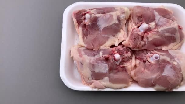 슈퍼마켓에서 판매되는 식품용 플라스틱 쟁반에 닭고기 허벅지 수평으로 매끈하게 — 비디오