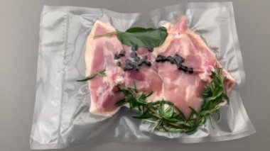 Biberiyeli tavuk butları ve vakumlu baharatlar üst görünümde Gri arka planda Sous vide pişirme Kaydırıcı Dolly için paketlendi.