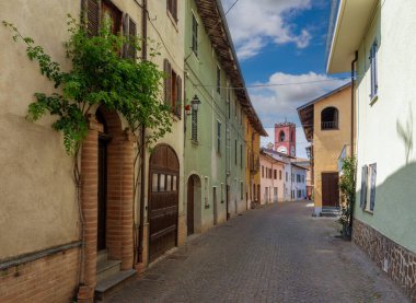 Dogliani, Langhe, Piedmont, Italy - May 17, 2022: via Ritiro with civic clock tower in the ancient Borgo Castello (Castle Village)