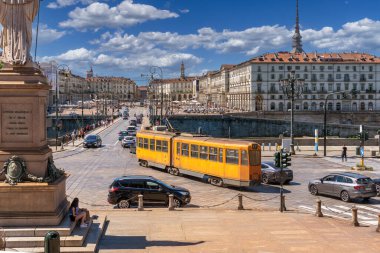 Torino, İtalya - 10 Haziran 2022: Tipik turuncu Torino tramvayı Piazza Gran Madre 'de Vittorio Emanuele I köprüsüne doğru, arka plandaki tarihi binalar ve Köstebek Veneto Meydanı' nda