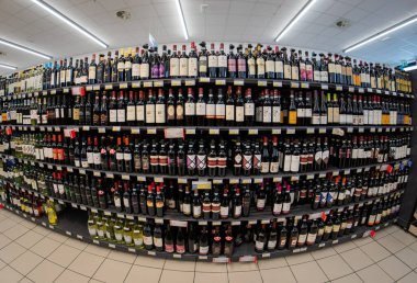 Fossano, İtalya - Haziran 2022: İtalyan süpermarketinde satılık şarap şişeleriyle raflar
