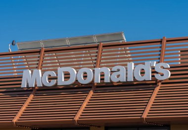 Savigliano, İtalya - 16 Haziran 2022: McDonald 's tabelası mavi gökyüzündeki restorantta, McDonald' s en büyük hamburger fast food zinciri.