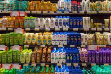 Fossano, Italy - August 11, 2022: Different brands and types of hair shampoo for sale on the shelf of an Italian supermarket