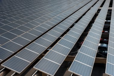 Rows of solar panels on parking. Photovoltaic solar cells energy farm for production of clean renewable energy from the sun rays
