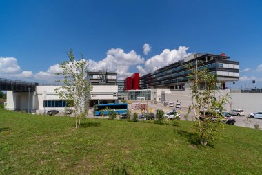 Verduno; Alba; Piedmont; Italy - October 12; 2021: the Michele and Pietro Ferrero Hospital; modern architecture of ASL CN2 hospital of Alba; Bra and Langhe. On blue sky and white cloud
