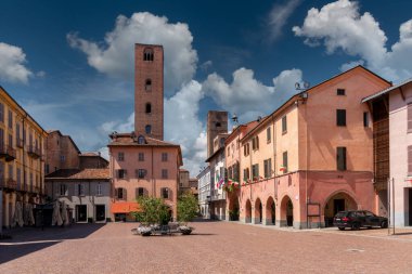 Alba, Langhe, Piedmont, Italy - August 16, 2022: Piazza Risorgimento historic center of the city with the town hall, the arcades and the medieval towers of the age of the communes