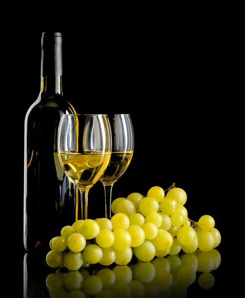 Бутылка вина и куча белого винограда — стоковое фото