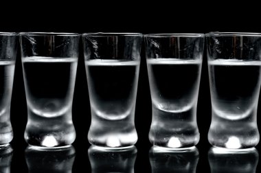 birçok bardak votka siyah arka plan üzerine izole