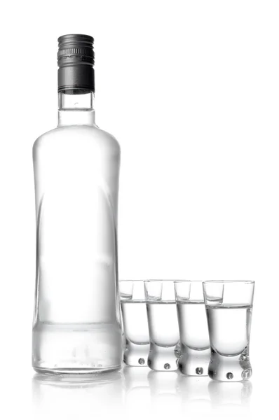 Garrafa e copos de vodka isolados em branco — Fotografia de Stock