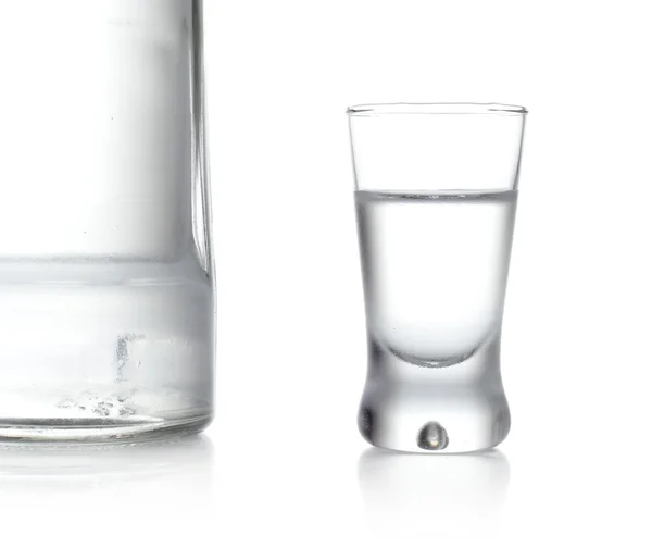 Fles en glas wodka staande geïsoleerd op witte achtergrond — Stockfoto