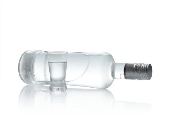 Fles en glas van wodka liegen geïsoleerd op witte achtergrond — Stockfoto