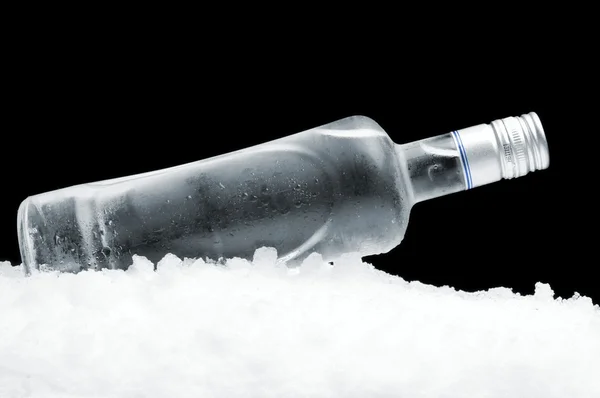 Garrafa de vodka deitada no gelo no fundo preto — Fotografia de Stock