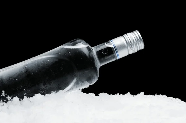 Flasche Wodka auf Eis liegend auf schwarzem Hintergrund — Stockfoto