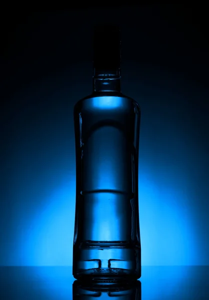 Bottle of vodka lit with blue backlight — Stock Photo, Image