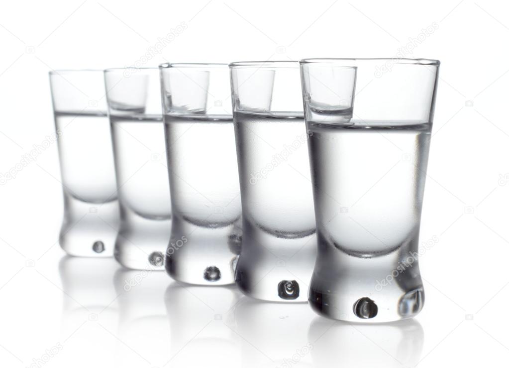 Five glasses of vodka isolated on white