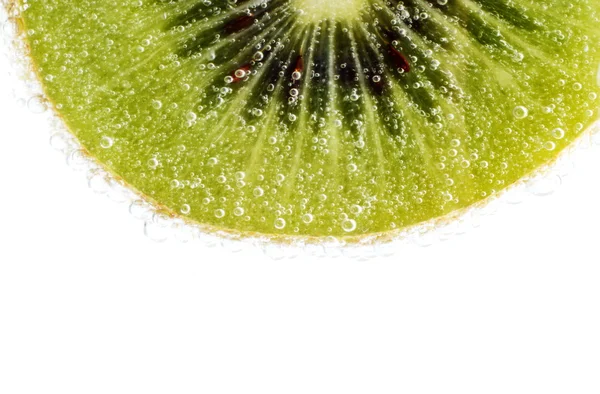 Hintergrund einer Kiwi-Scheibe mit Wassertropfen, die mit Licht angezündet wurde — Stockfoto